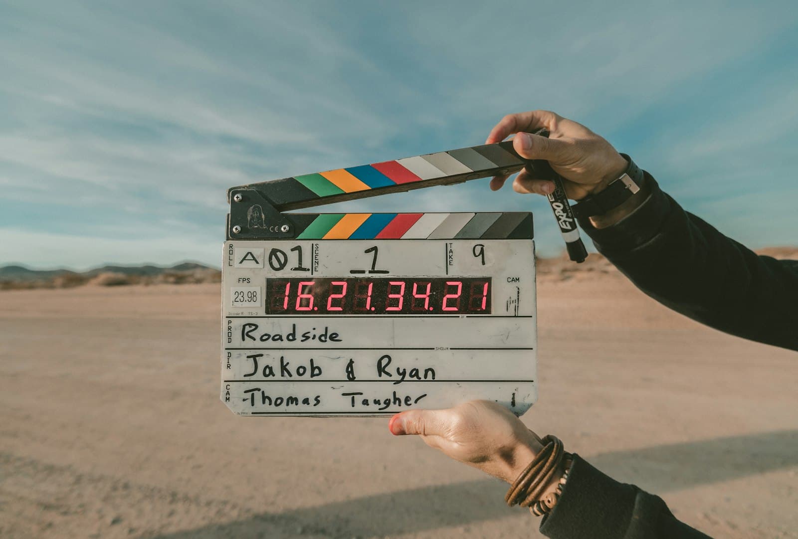 Hand holding a film clapperboard outdoors