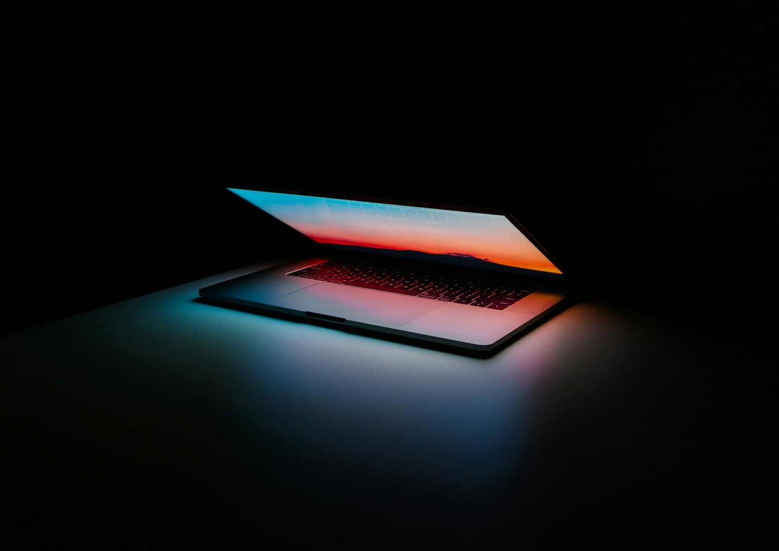 Laptop with a softly glowing screen in a dark room