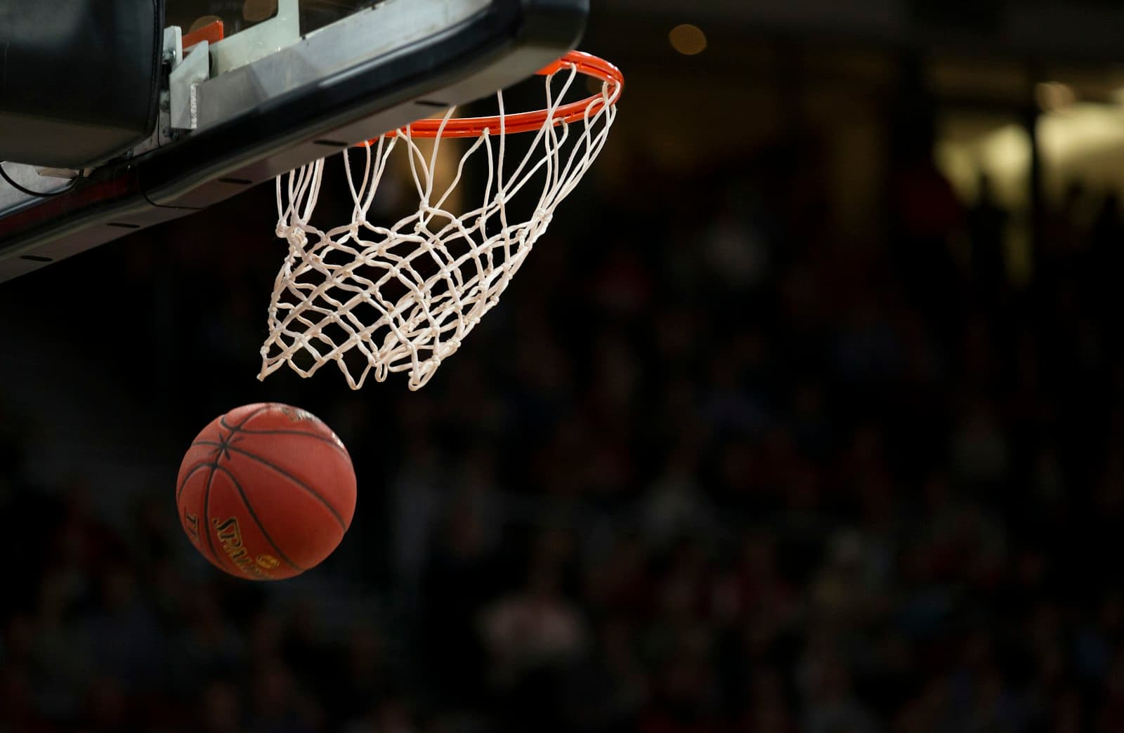 Basketball dropping through the hoop in an arena